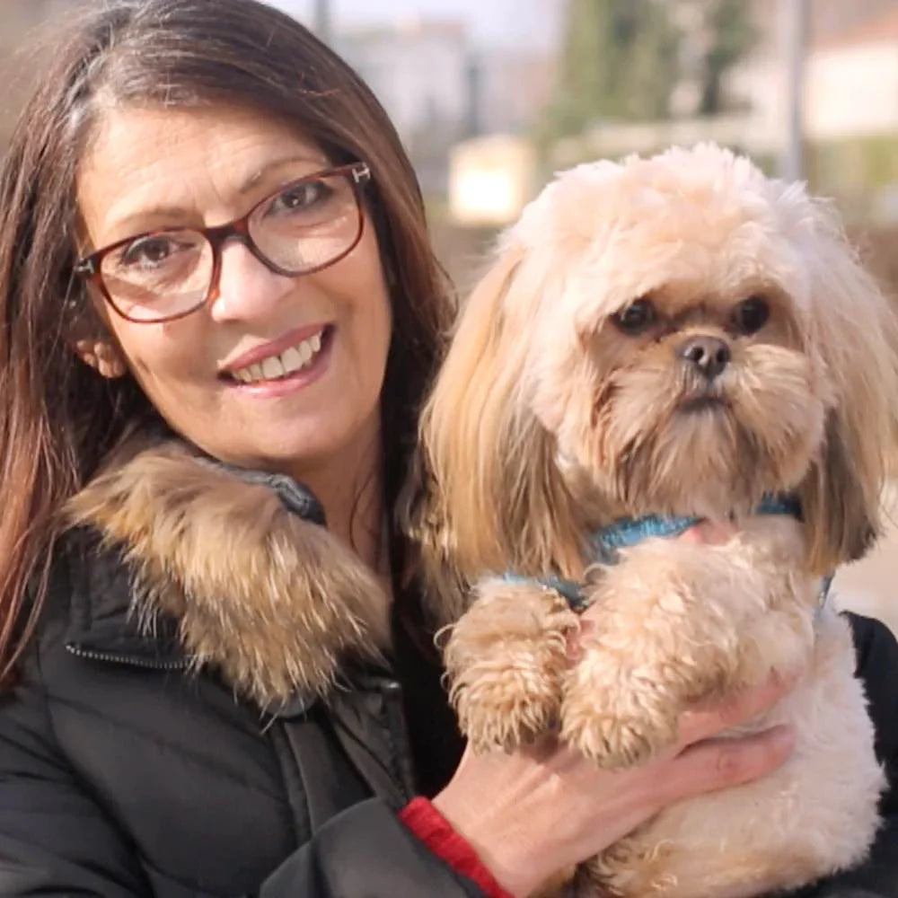 Frau hat Hund auf dem Arm